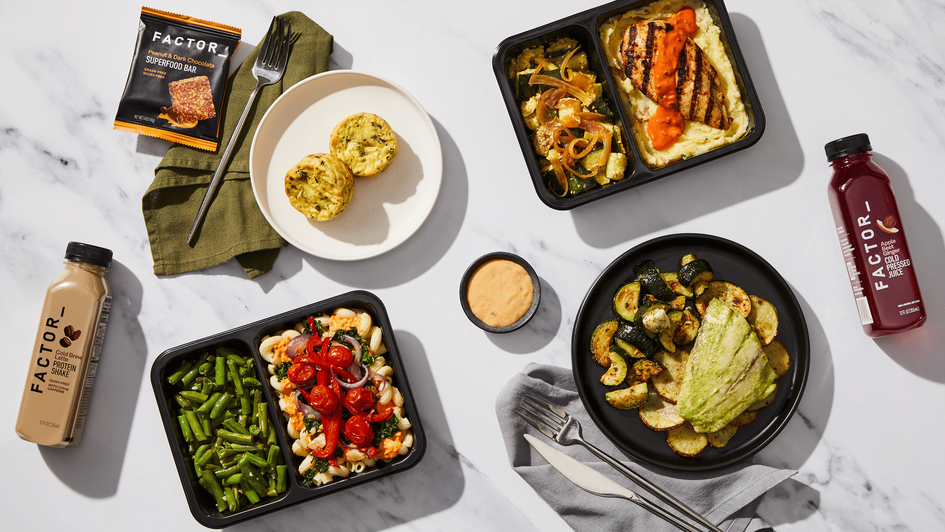 Factor meal tray with pasta and green beans, served with egg bites, a protein shake, and a superfood bar.