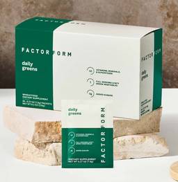 Factor Form branded box with daily greens powder packet in front, on aesthetic marble slab