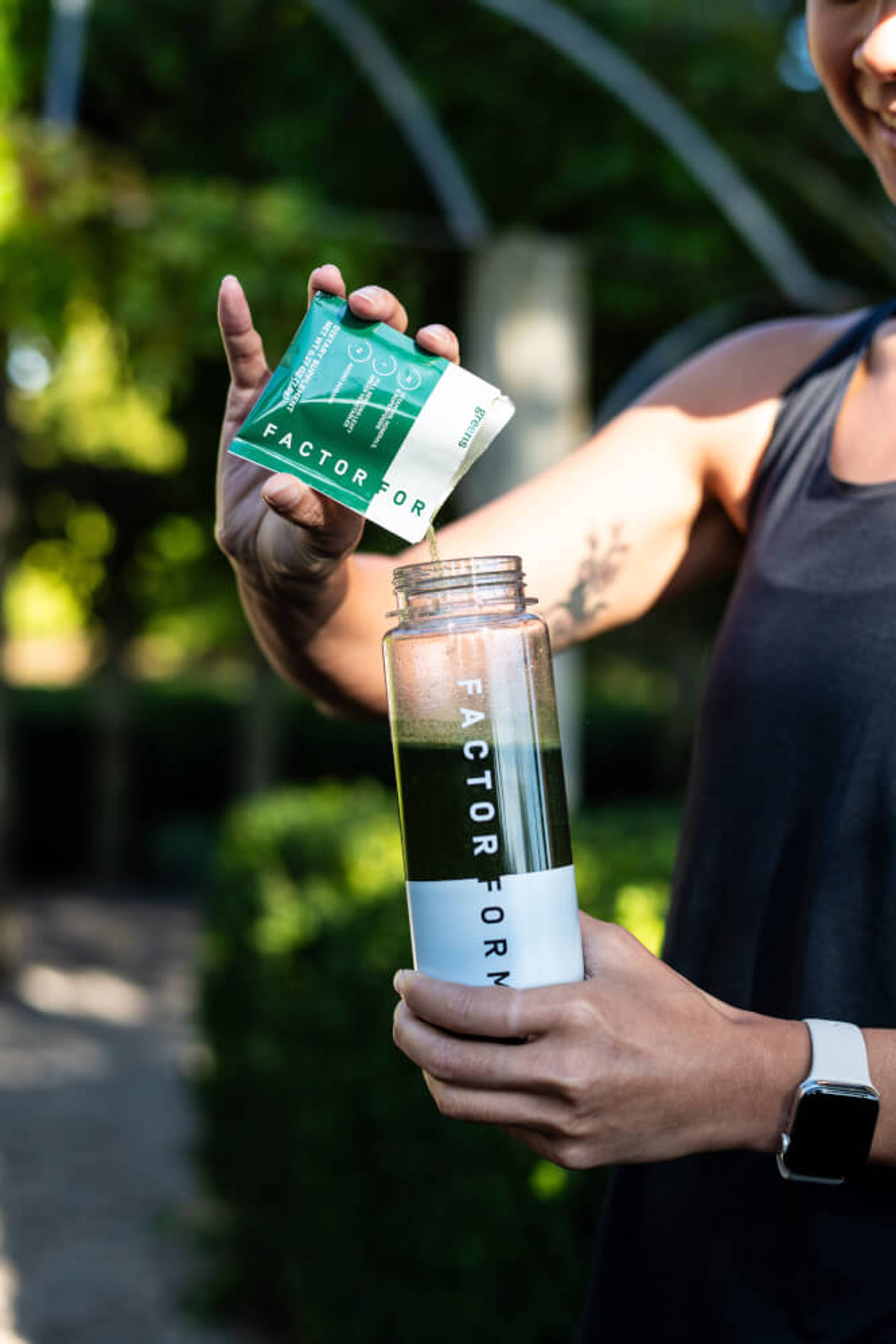 Lifestyle image of person pouring Factor Form product into a Factor Form shaker bottle