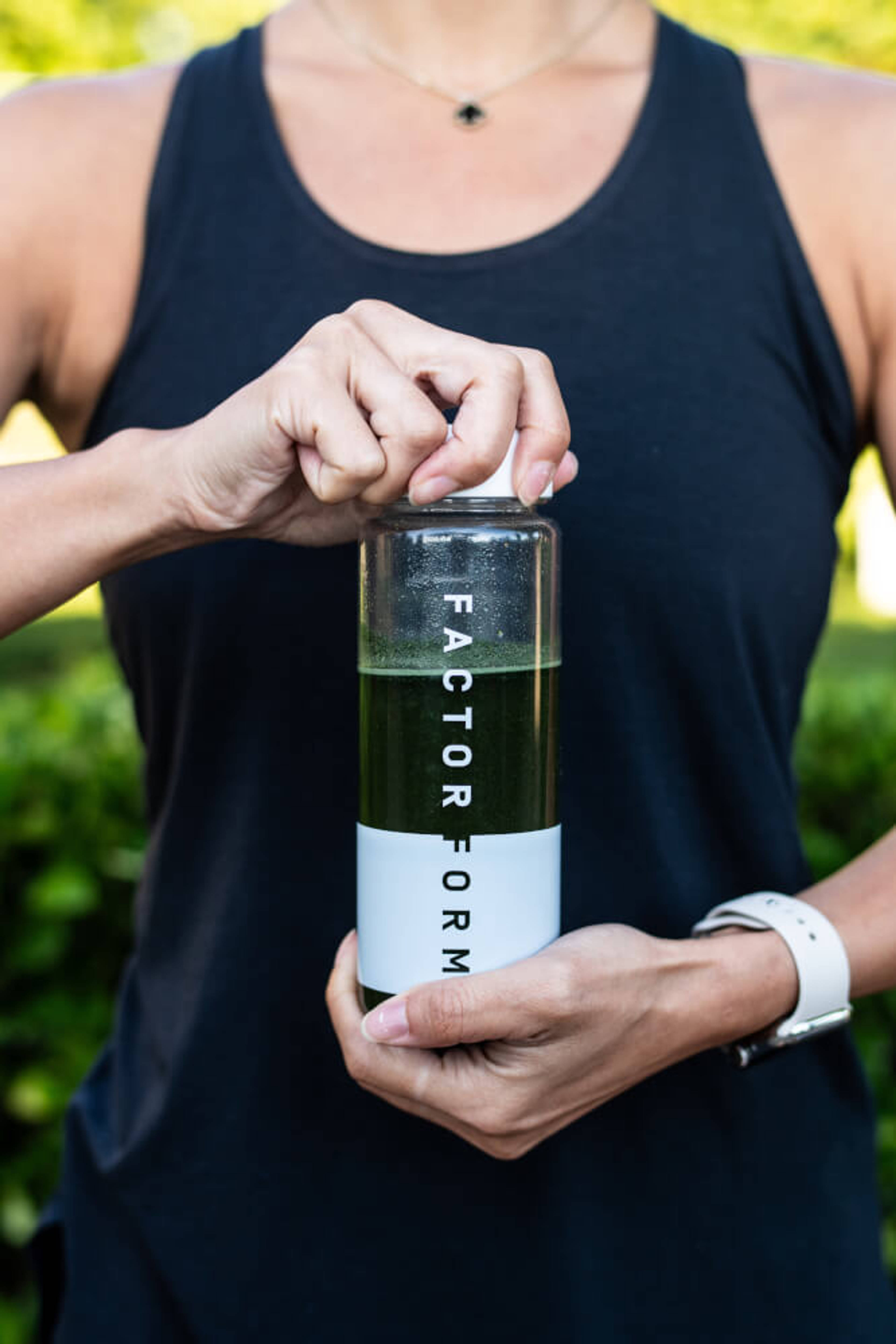 Lifestyle image of person holding a Factor Form bottle with mixed product
